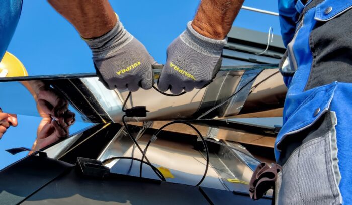 People installing solar panel, for article on france green roof law